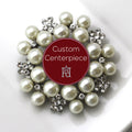 A silver brooch with clear crystals and faux pearls designed as a custom centerpiece.