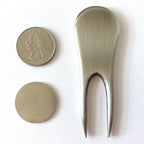 Metallic spoon and coin on a white background