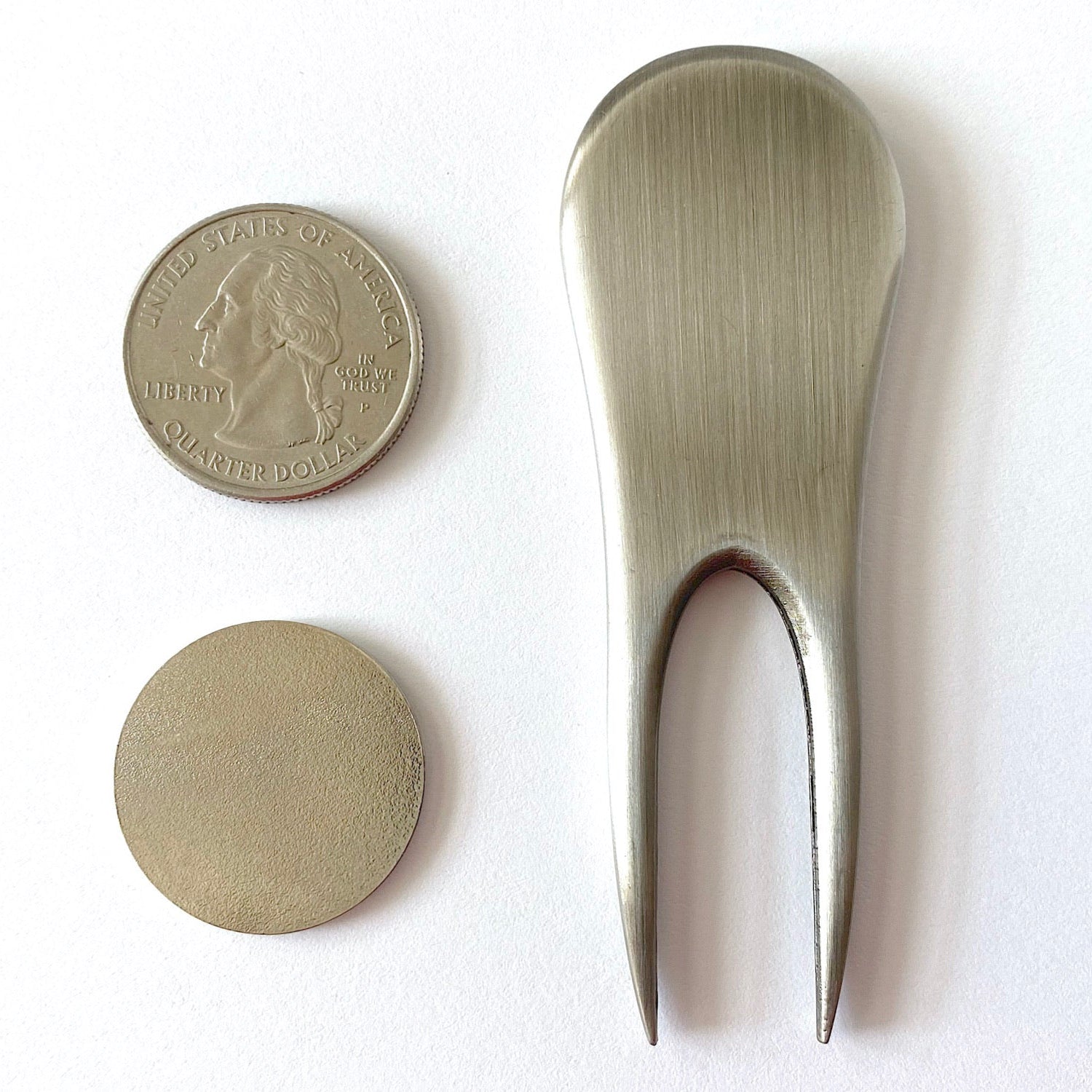 Metallic spoon and coin on a white background