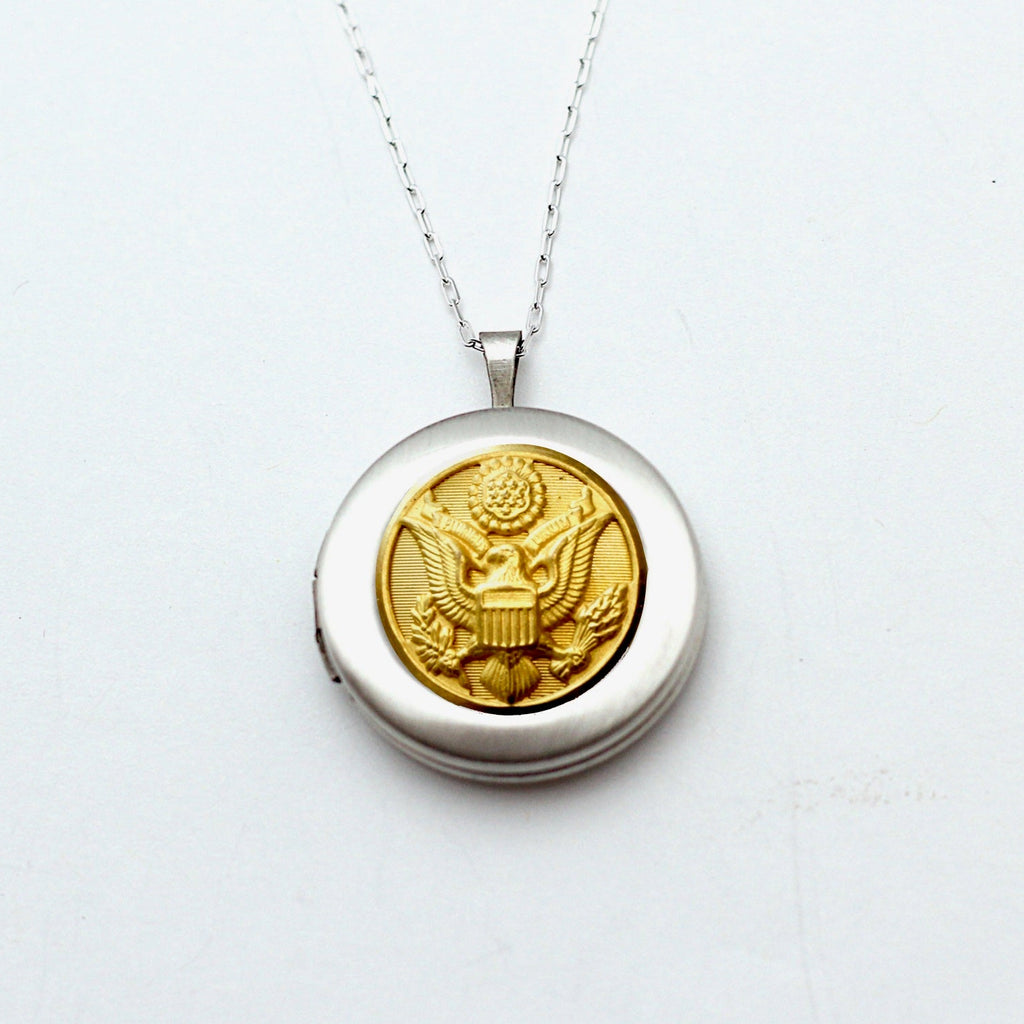 A silver locket necklace featuring a button design, with a silver chain and a lobster claw clasp, on a white background.