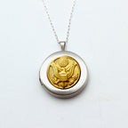 A silver locket necklace featuring a button design, with a silver chain and a lobster claw clasp, on a white background.