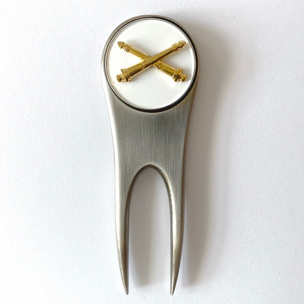 Golf divot tool with gold accents on a white background