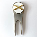 Golf divot tool with gold accents on a white background