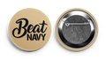 Two round supporter buttons, one with 'BEAT NAVY' text and a tugboat graphic, and the other with a close-up of the button's surface showing the text and metal edge.