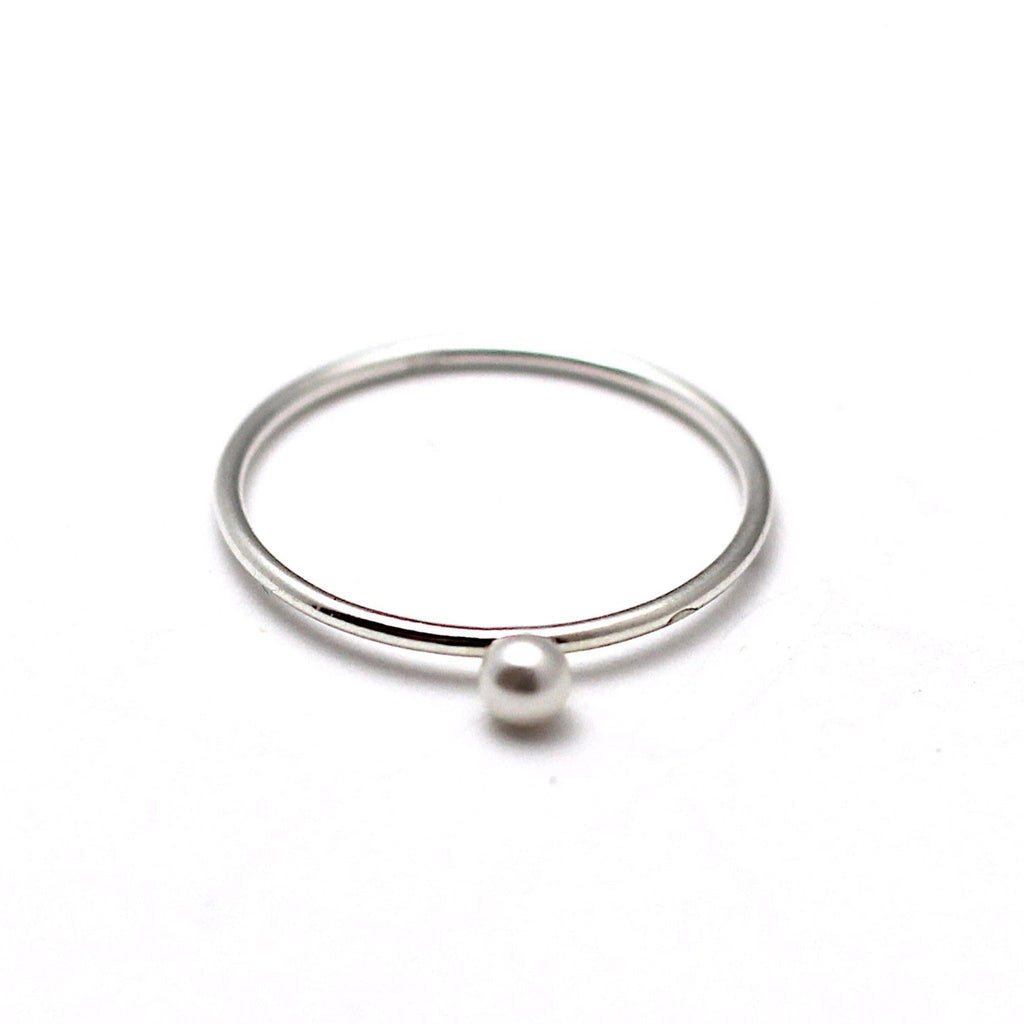 A sterling silver ring with a Swarovski pearl embellishment on a white background.