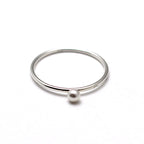 A sterling silver ring with a Swarovski pearl embellishment on a white background.