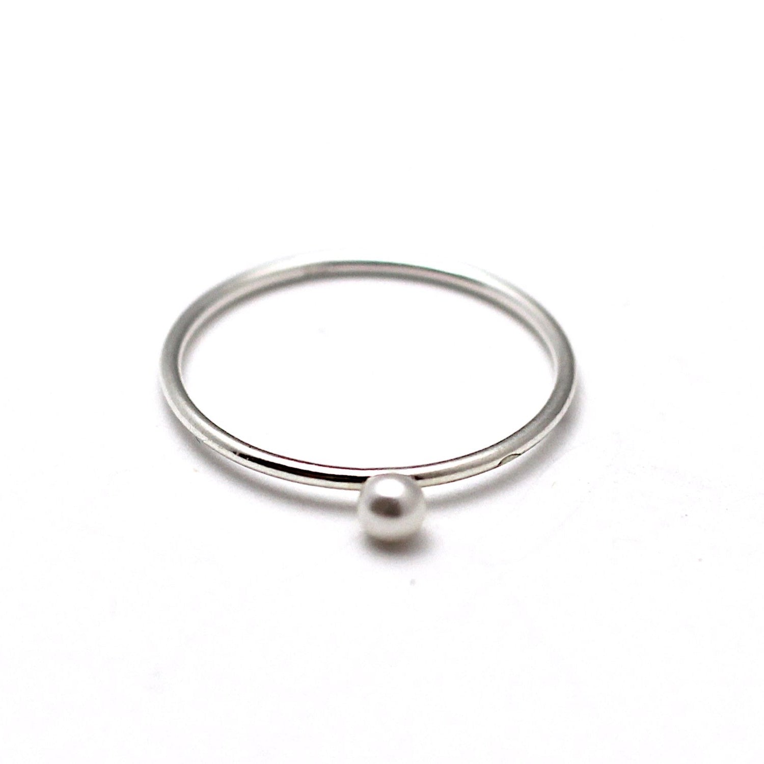 A sterling silver ring with a Swarovski pearl embellishment on a white background.