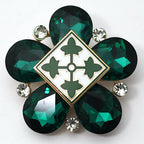 A limited edition brooch featuring a green, geometric-shaped insignia with a '4ID' emblem in the center surrounded by green rhinestones and smaller white and black stones along the perimeter.