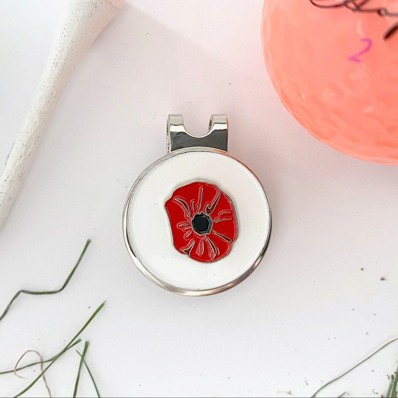 Red poppy design on a white background with a silver clip