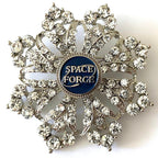A brooch with a central Space Force emblem surrounded by crystal rhinestones on a shield-shaped background.