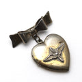 A vintage WWII-era sweetheart pin with a heart locket featuring aviation 'prop and wings' symbol, and a bow and arrow emblem, primarily in silver color.