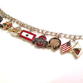 A sterling silver bracelet with a lobster clasp closure, featuring five charms with various designs, including a flag and an emblem.